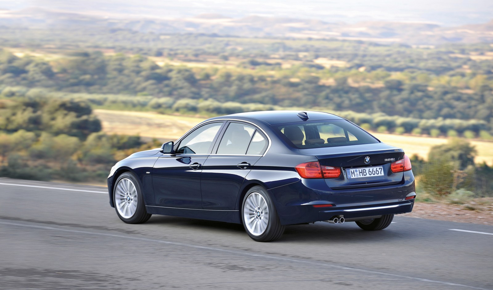 BMW Serie 3 F30 azul oscuro en carretera, vista trasera de tres cuartos