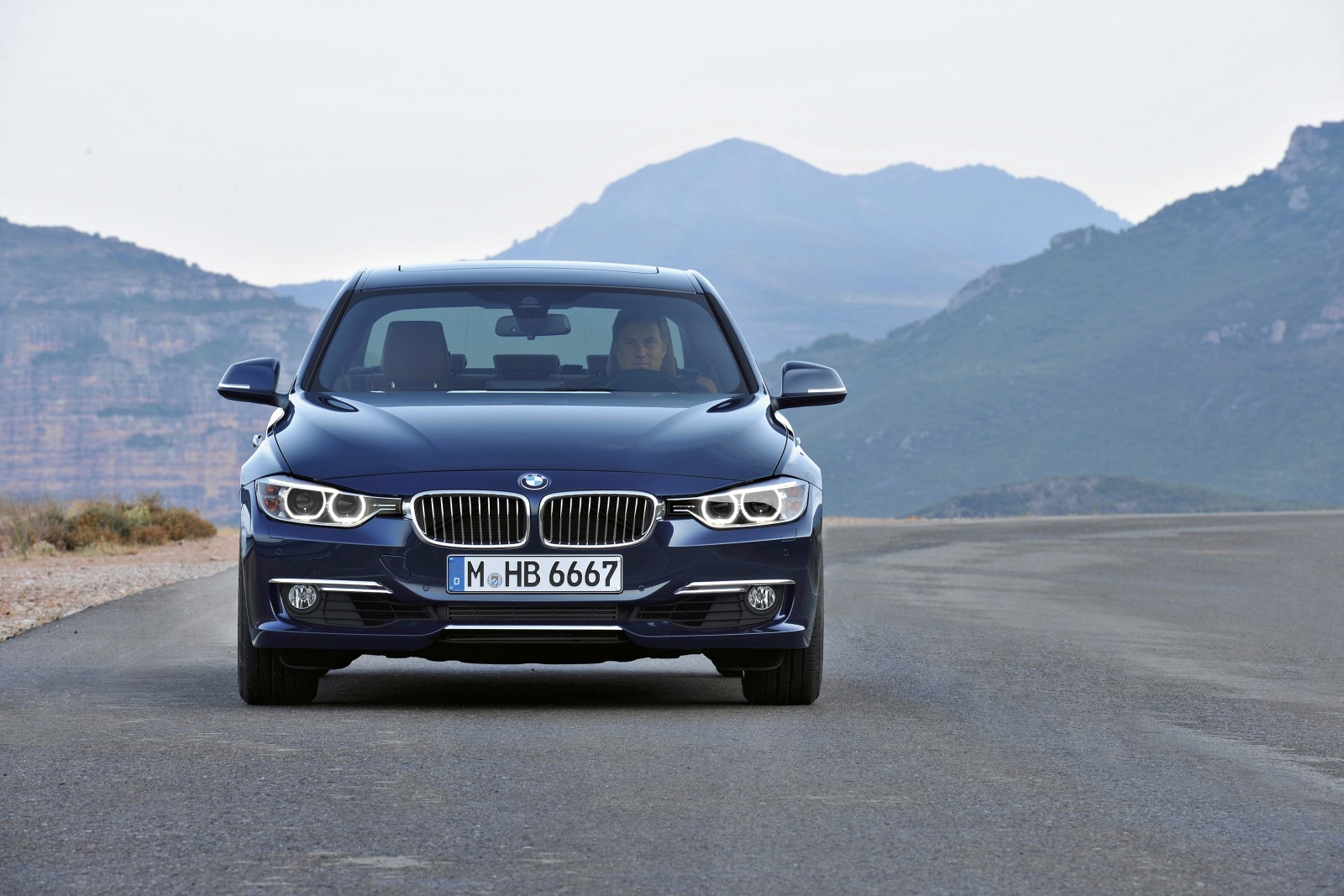 BMW Serie 3 F30 azul visto de frente en una carretera de montaña