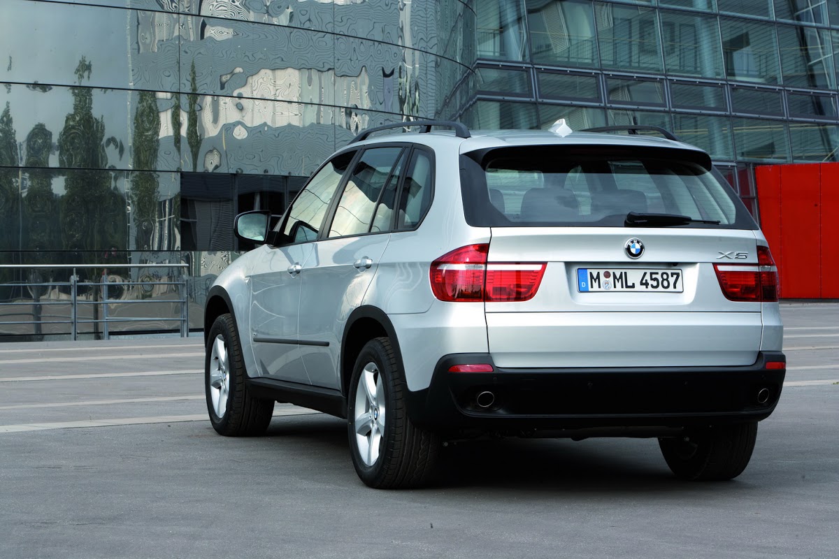 BMW X5 E70 blanco visto desde atrás ante un edificio