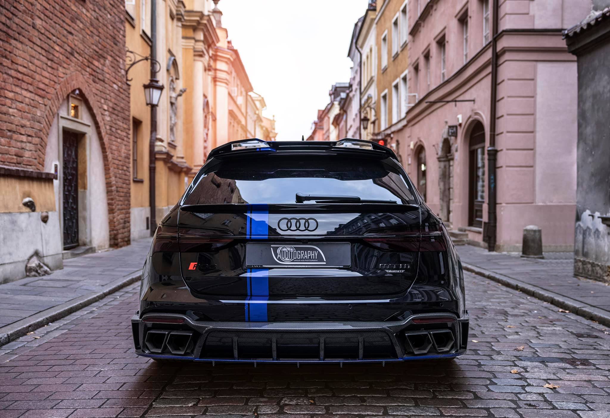 Vista trasera del Audi RS6 Avant de MTM y Mansory en una calle urbana empedrada.