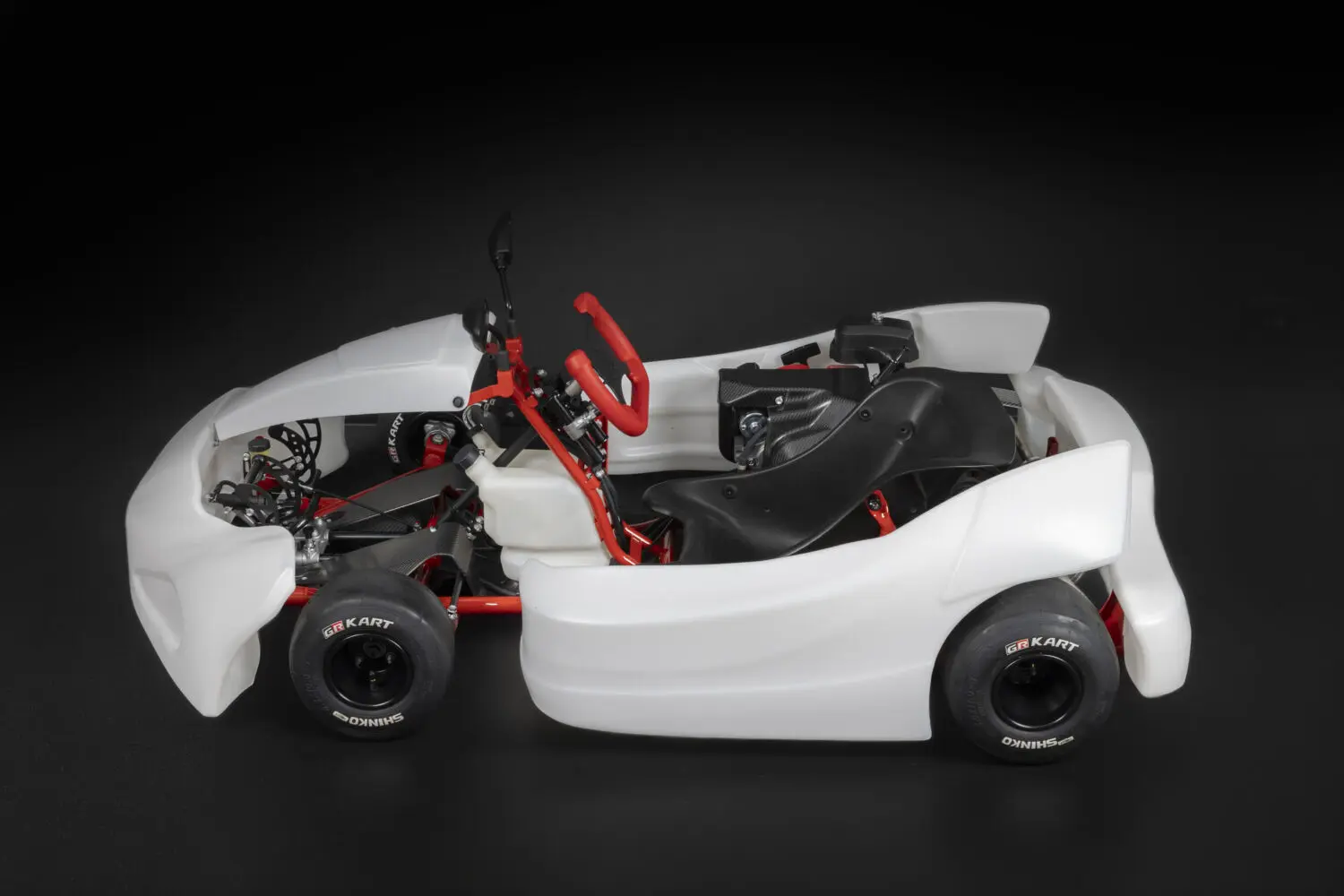 Vista lateral del Toyota GR KART blanco con bastidor rojo