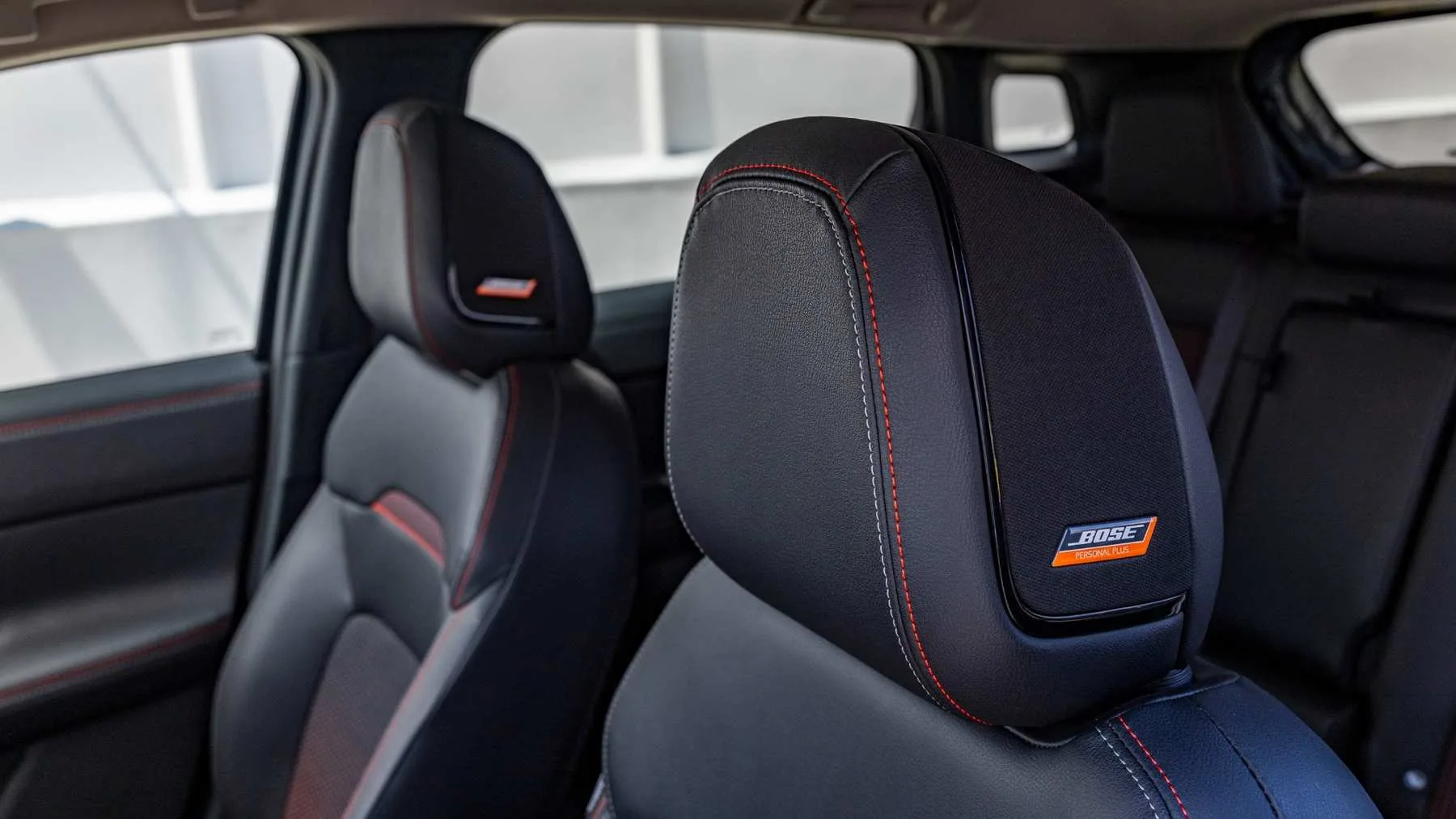 Detalle del asiento delantero del Nissan Kicks con reposacabezas y distintivo Bose Personal Plus.