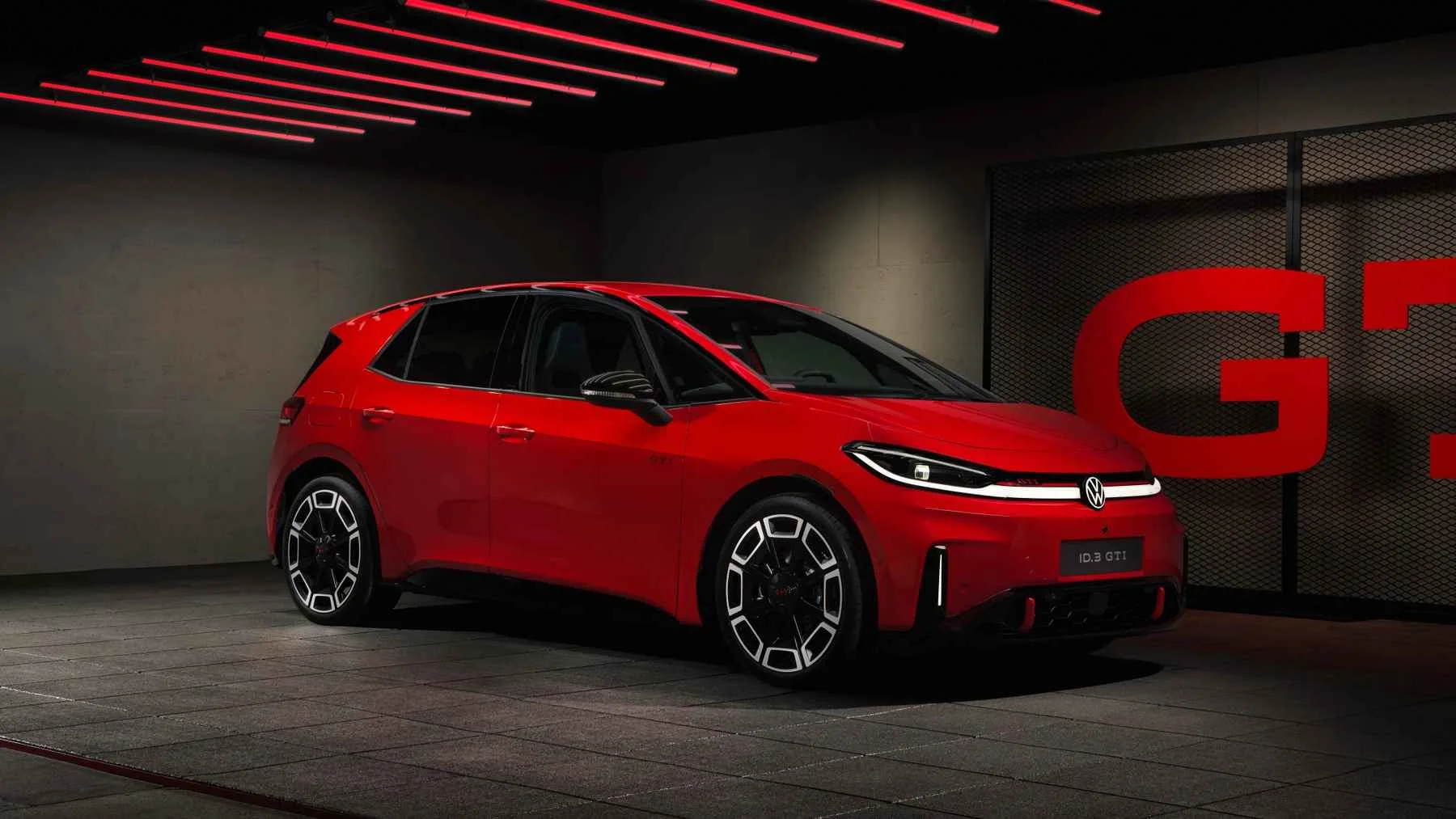 Volkswagen ID.3 GTI rojo en un estudio con iluminación roja, visto de frente y de lado