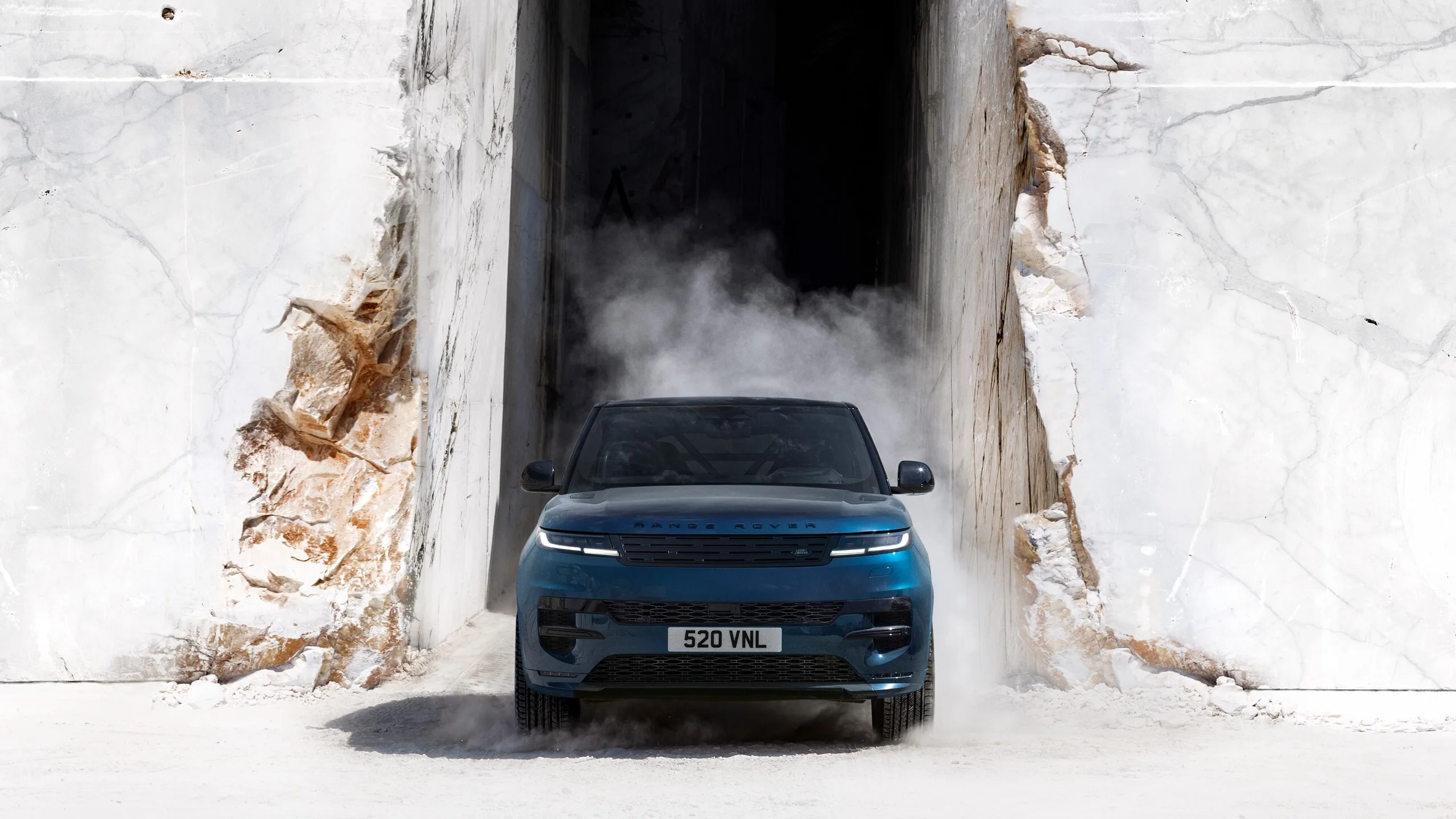 Range Rover Sport azul visto de frente entre paredes de roca