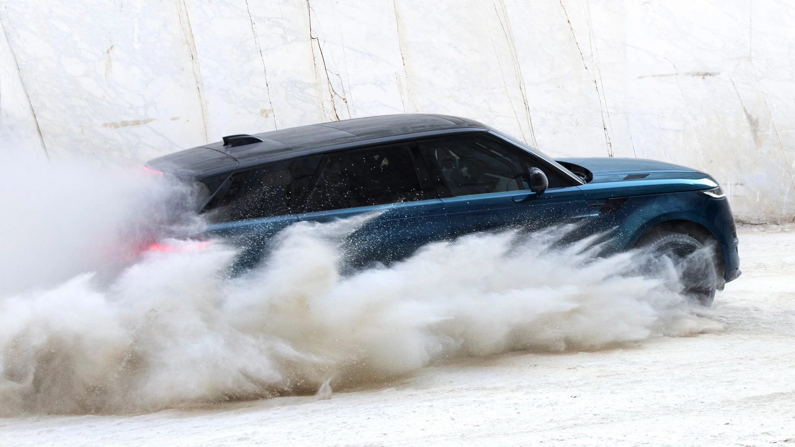El SUV azul atraviesa la nieve mientras levanta polvo