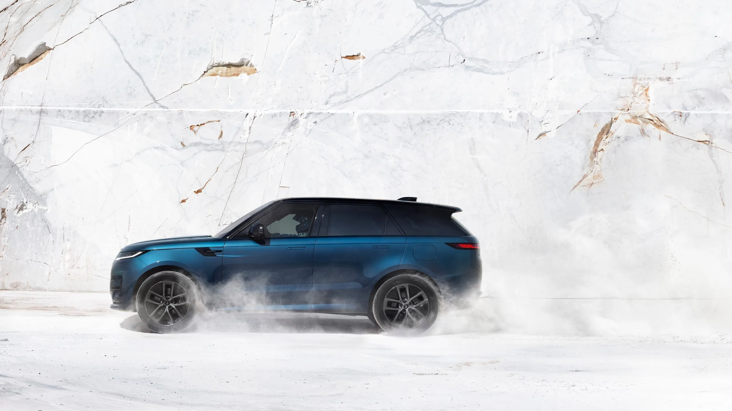 Perfil del SUV azul mientras derrapa sobre la nieve