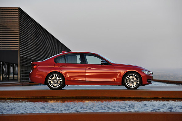 BMW Serie 3 F30 rojo frente a un edificio de fachada oscura
